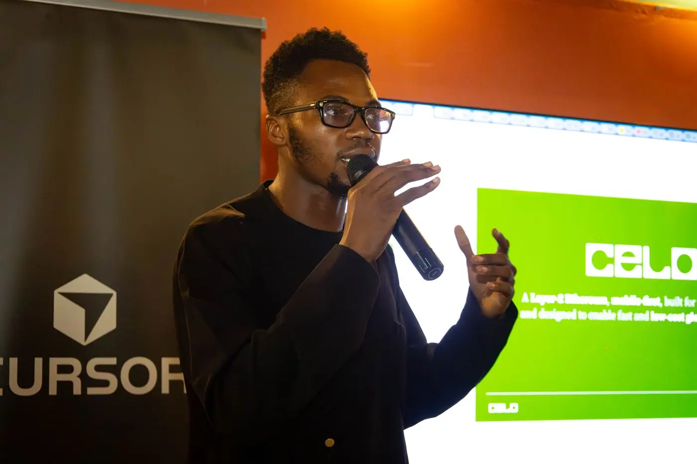 Edidiong speaking at Café Cursor Lagos in front of a Celo slide